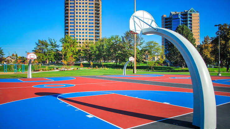 Colorful basketball courts at McEuen Park with downtown high-rises behind